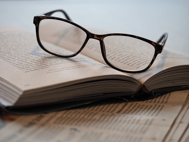 A pair of glasses on top of an open book.